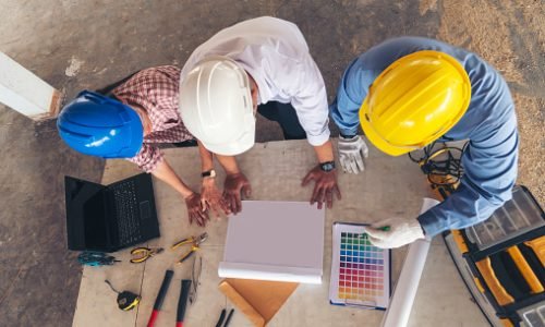 Construction engineer teamwork Safety Suit Trust Team Holding White Yellow Safety hard hat Security Equipment on Construction Site. Hardhat Protect Head for Civil Construction Engineer Concept