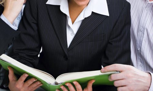 Image of business people reading the book which the woman holding